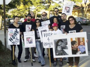 Rosemary Duenez , far right, holds photo of her son, Ernest Duenez Jr, killed by police.WW photo: Dante Strobino