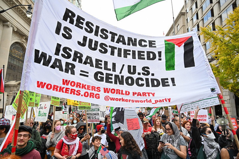Banner reads Resistance is Justified. Israeli/U.S. war = genocide