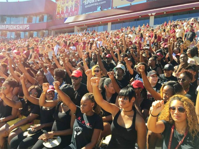 Florida State University students sit during national anthem, Oct. 8.