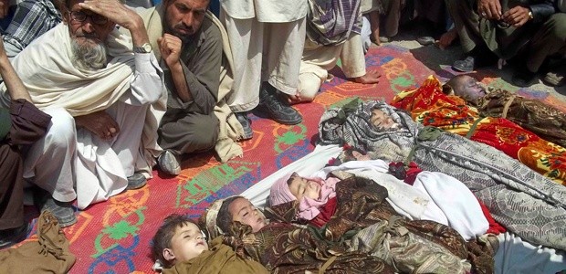 Afghan villagers sit near the bodies of children killed during a U.S.-led NATO airstrike in Kunar province on April 7, 2013.