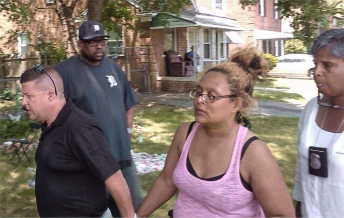 UAW Local 600 second Vice-President A.J. Freer escorts Jeanette Shannon into her besieged home to retrieve belongings. Bailiff seen wearing badge following behind.